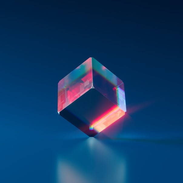 Transparent cube emitting red reflexes on dark blue background